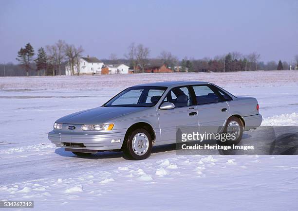 Ford Taurus in snow covered field, 2000.