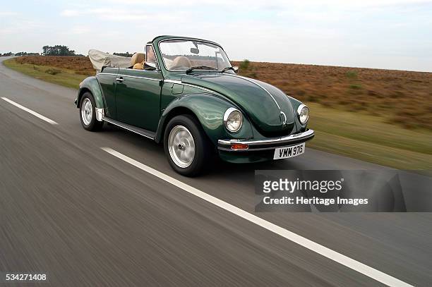 Volkswagen Beetle driving along road, 2000.