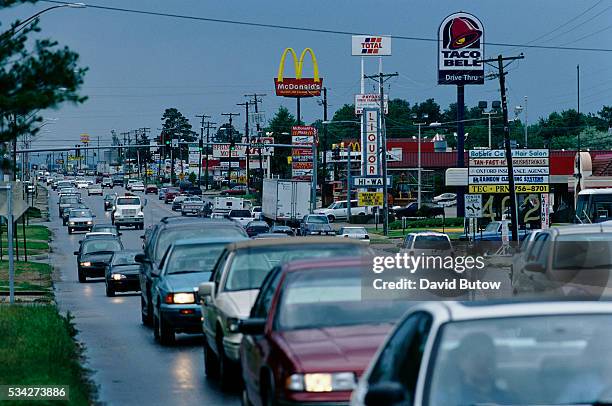 Typical "strip" of highway businesses including signs for McDonalds and Taco Bell fast food restaurants along U.S. Highway 412 in Springdale, a town...