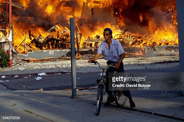 Man on Bicycle near Burning Building