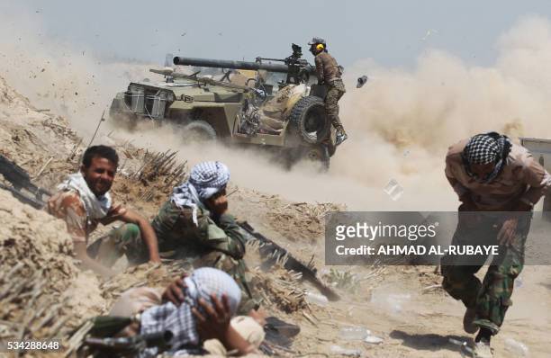 Iraqi pro-government forces fire an anti-tank cannon near al-Sejar village, north-east of Fallujah, on May 25 as they take part in a major assault to...