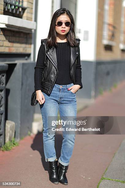 May Berthelot , is wearing an Iro sleeveless black leather jacket, The Kooples blue jeans, Zara black leather boots, a Chanel cachemire black body...