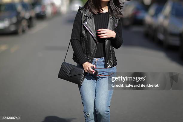 May Berthelot , is wearing an Iro sleeveless black leather jacket, The Kooples blue jeans, Zara black leather boots, a Chanel cachemire black body...