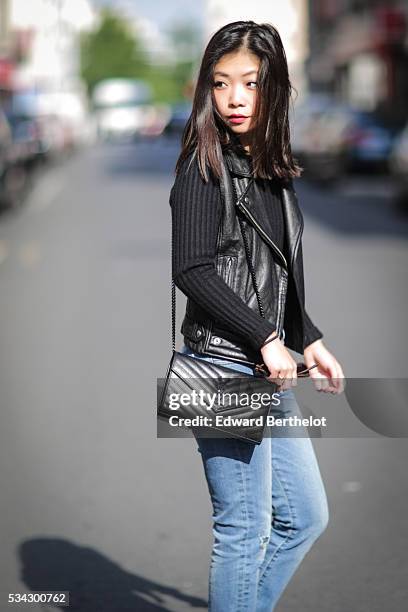 May Berthelot , is wearing an Iro sleeveless black leather jacket, The Kooples blue jeans, Zara black leather boots, a Chanel cachemire black body...