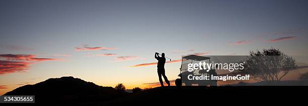 male caucasian golfer swinging a golf club with cart - golf swing sunset stock pictures, royalty-free photos & images