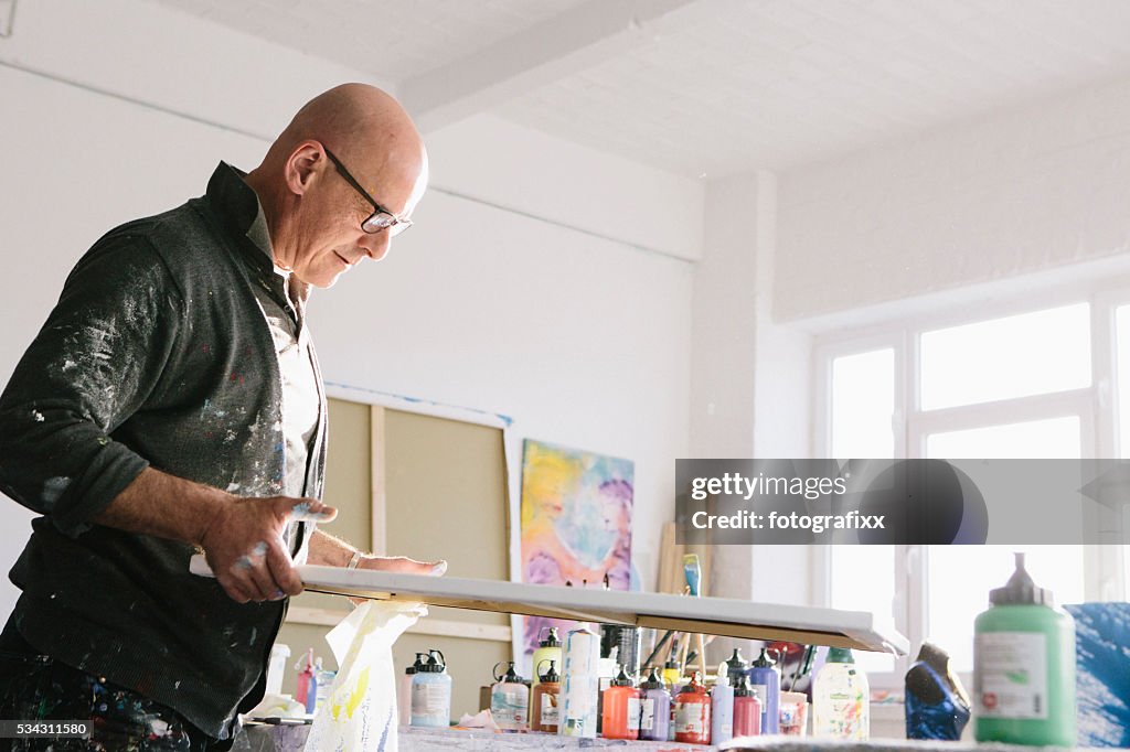 Männliche Künstler arbeiten auf seinem Gemälde in seinem studio