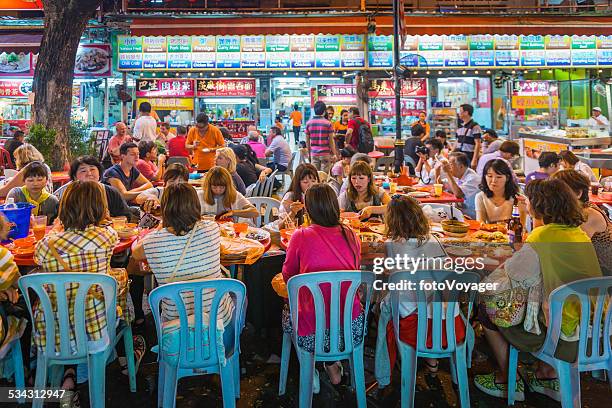 group of women at crowded outdoor restaurant kuala lumpur malaysia - street food stock pictures, royalty-free photos & images