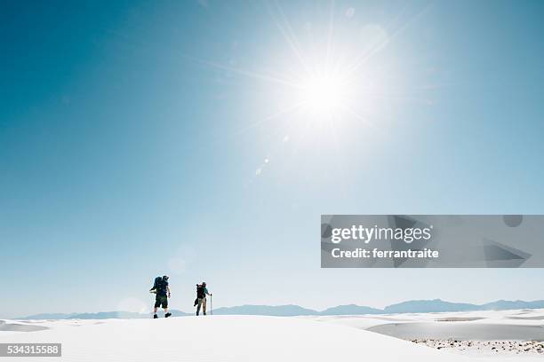 backpackers hiking on the desert dunes - minimal effort stock pictures, royalty-free photos & images