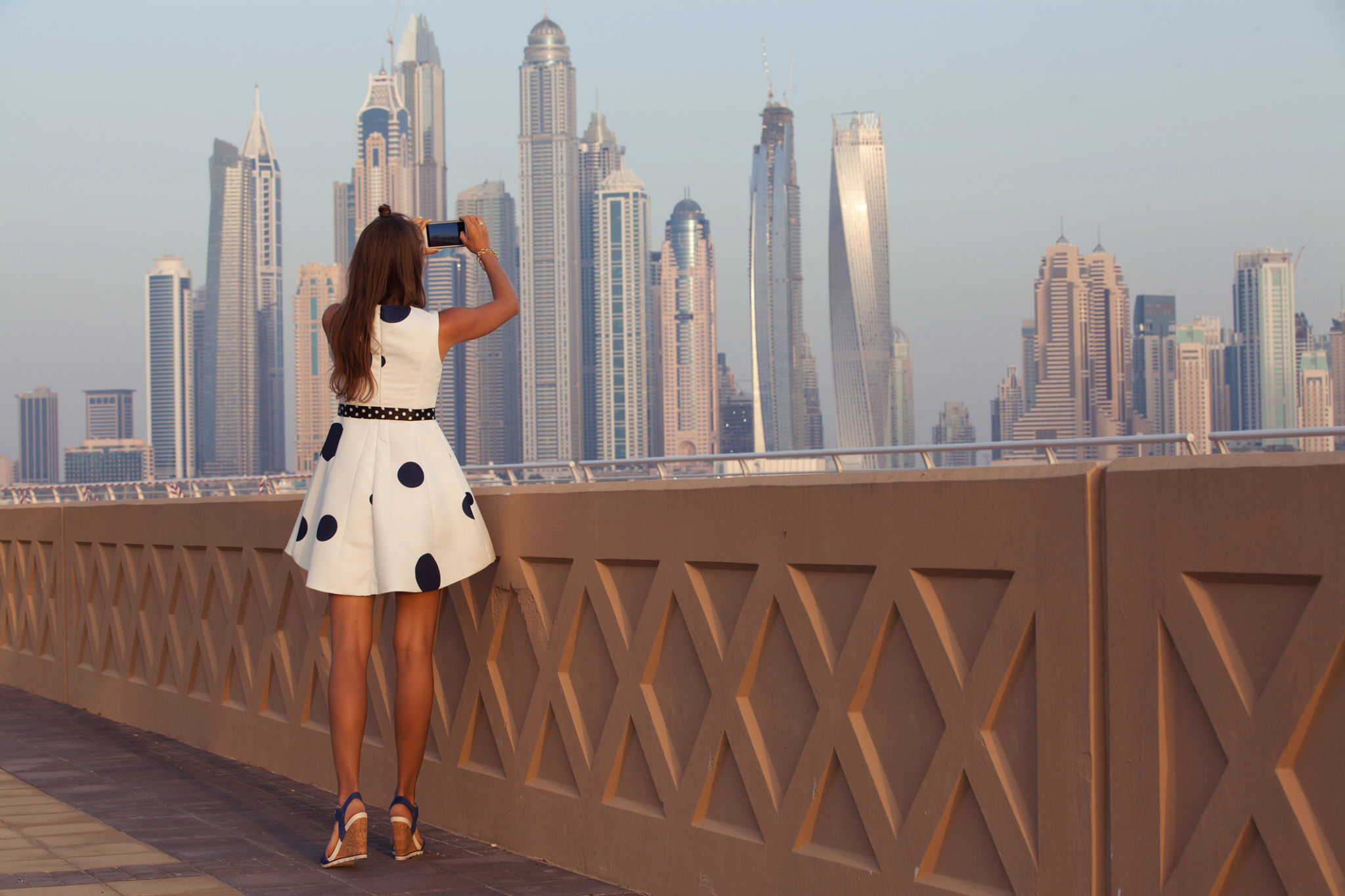 Tourist taking travel picture with phone of Dubai City skyline. Tourist taking travel picture with phone of Dubai City skyline.