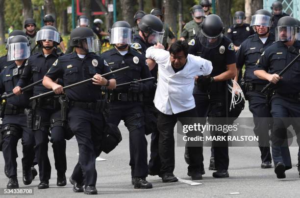 Police arrest a protestor during an anti-Trump demonstration outside the Anaheim Convention Center prior to a rally for Republican presidential...