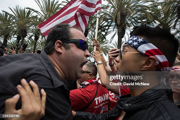 An anti-Trump protester and a Trump support clash outside a campaign rally by presumptive GOP presidential candidate Donald Trump at the Anaheim...