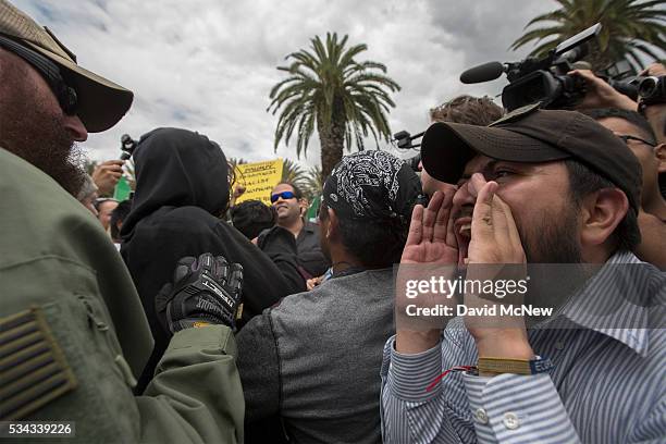 An anti-Trump protester yells at a Trump supporting street preacher clash a campaign rally by presumptive GOP presidential candidate Donald Trump at...