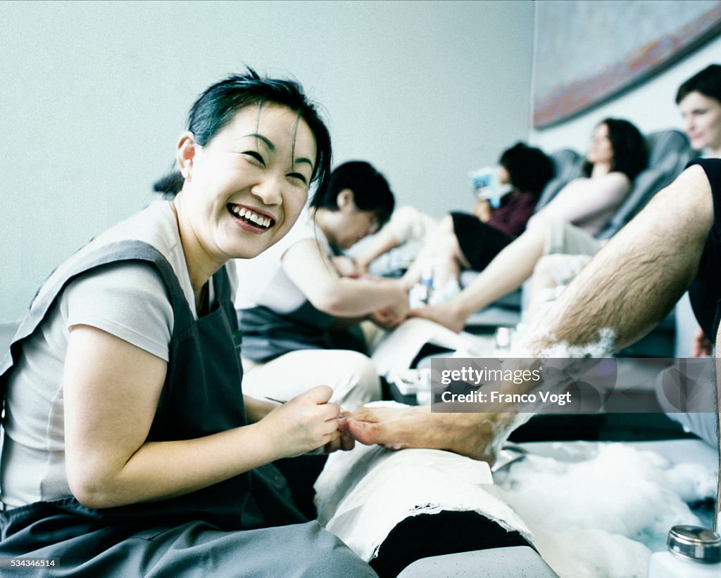 Woman Giving Man Pedicure at Beauty Shop