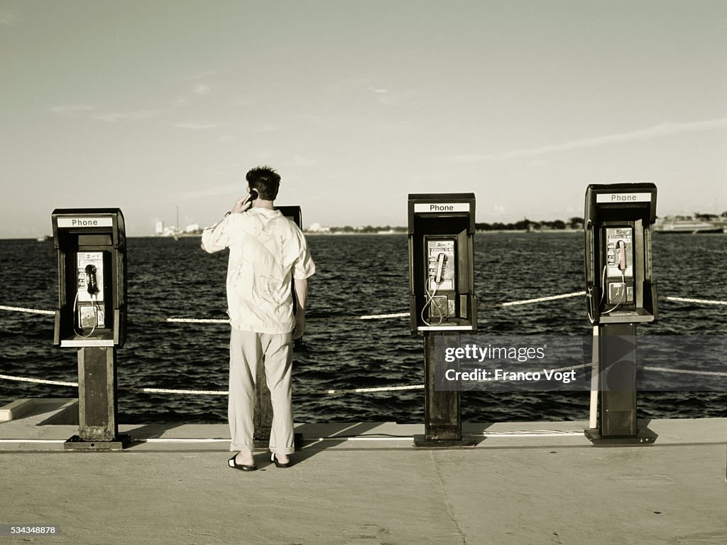 Man Using Pay Phone On Boardwalk