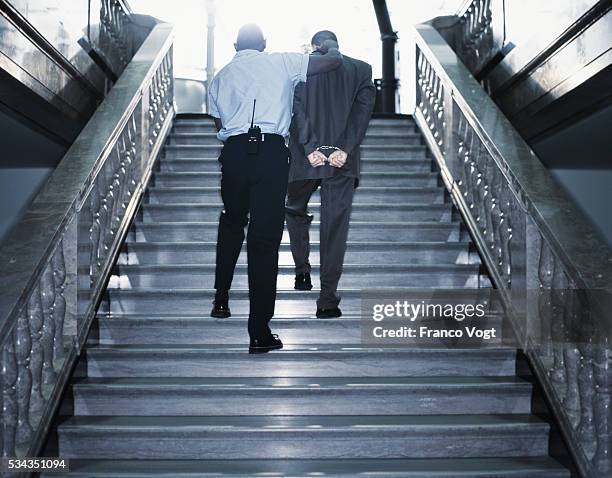 police officer leading handcuffed man - nachtwächter historisch stock-fotos und bilder