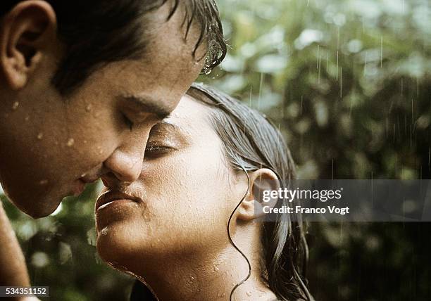 man and woman kissing in rain - couples kissing shower stockfoto's en -beelden