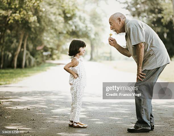old man and little girl in road - kindness stock pictures, royalty-free photos & images