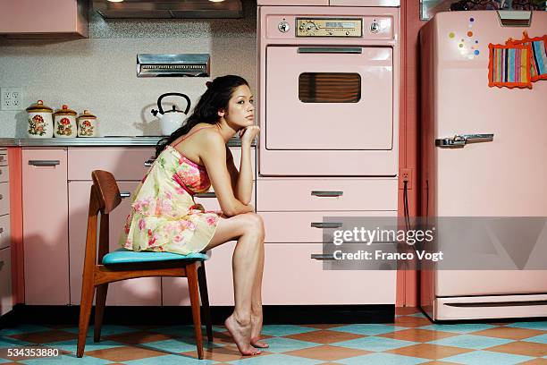 bored woman sitting in kitchen - stereotypical housewife bildbanksfoton och bilder