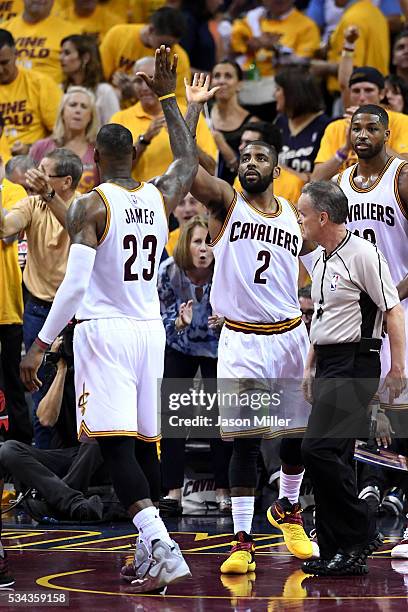 LeBron James and Kyrie Irving of the Cleveland Cavaliers react after a play in the third quarter against the Toronto Raptors in game five of the...