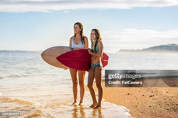 mother and daughter surfers - hawaii vacation and parent and teenager stock pictures, royalty-free photos & images