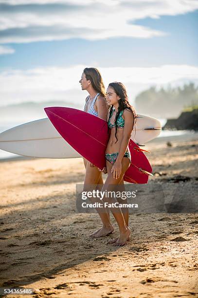 mother and daughter surfers - hawaii vacation and parent and teenager stock pictures, royalty-free photos & images