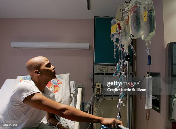 Eighteen-year-old cancer patient Patrick McGill looks at a rack holding bags of chemotherapy while receiving treatment for a rare form of cancer at...