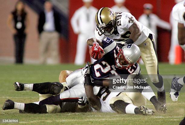 Ellis Hobbs of the New England Patriots is tackled by Josh Bullocks and Alfred Fincher of the New Orleans Saints during a kickoff return in their...
