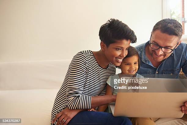 showing her daughter the world...wide web - two parents stock pictures, royalty-free photos & images