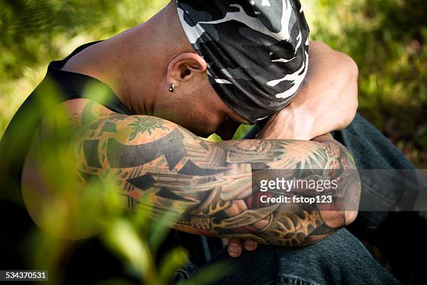 characters: sad man with tattoos and piercings contemplates. nature. - do rag 個照片及圖片檔