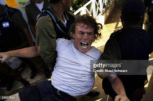 Settler protester is taken away by military police from the synagogue after it was raided August 18, 2005 in the Israeli settlement of Neve Dekalim...