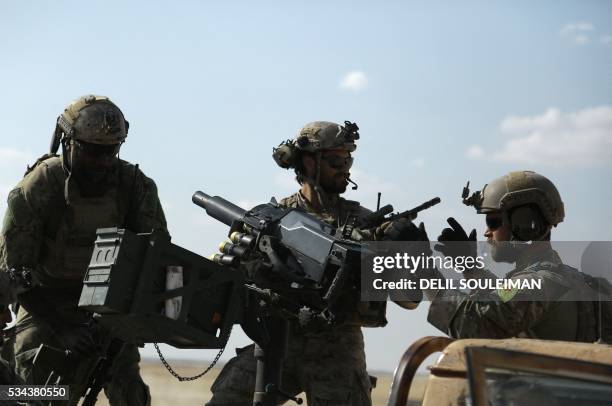 Men in uniform identified by Syrian Democratic forces as US special operations forces ride in the back of a pickup truck in the village of Fatisah in...