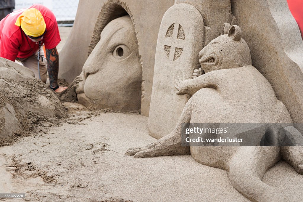 Cat and mouse sculpture in sand