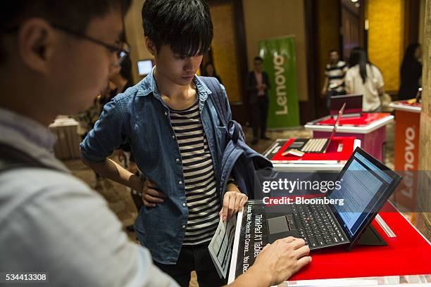 Attendees look at a Lenovo Group Ltd. ThinkPad X1 laptop computer ahead of a news conference in Hong Kong, China, on Thursday, May 26, 2016. Lenovo...