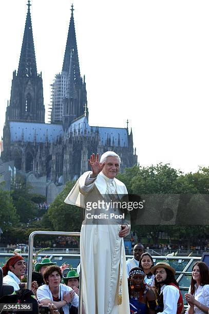 Pope Benedict XVI gestures on the boat in front of the Cologne Cathedral during his trip on Rhein River on August 18, 2005 in Cologne, Germany. Pope...