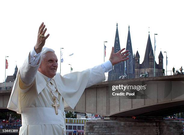 Pope Benedict XVI gestures on the boat in front of the Cologne Cathedral during his trip on Rhein River on August 18, 2005 in Cologne, Germany. Pope...