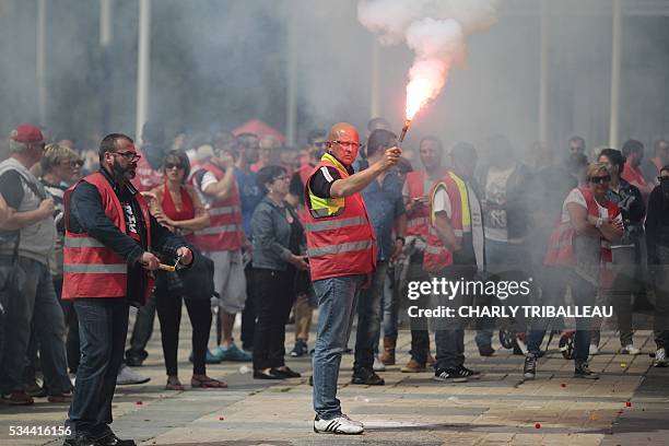 Man holds a flare a people demonstrate in Le Havre northwestern France, on May 26, 2016 to protest against the government's proposed labour reforms....