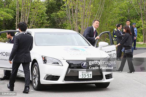 In this handout image provide by Foreign Ministry of Japan, Italian Prime Minister Matteo Renzi rides the automated driving vehicle during the...