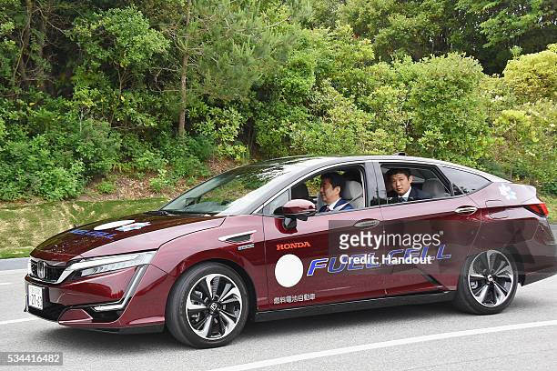 In this handout image provide by Foreign Ministry of Japan, Japanese Prime Minister Shinzo Abe rides the automated driving vehicle during the...