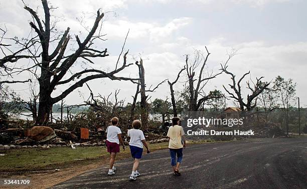 Residents survey the damaged caused by a tornado August 19, 2005 in Stoughton, Wisconsin. Tornadoes swept through southern Wisconsin the night before...