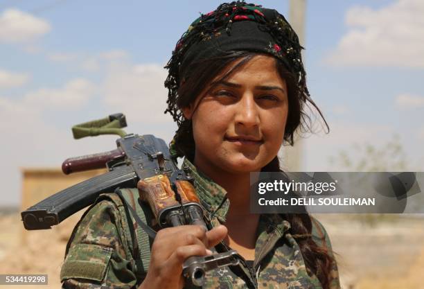 Fighter from the Kurdish People's Protection Units , part of the Syrian Democratic Forces , holds her weapon in the village of Fatisah in the...