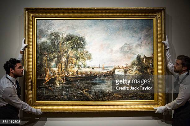 Christie's employees pose with 'View on the River Stour near Dedham' circa 1821-1822 by English painter John Constable at the auction house on May...