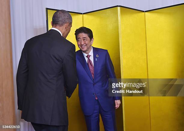 In this handout image provide by Foreign Ministry of Japan, U.S. President Barack Obama shakes hands with Japanese Prime Minister Shinzo Abe at the...