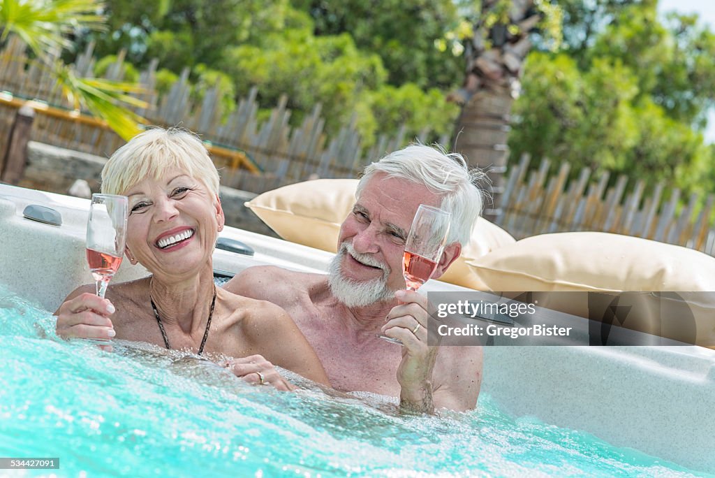 Senior Couple Drinking Wine in hot tub