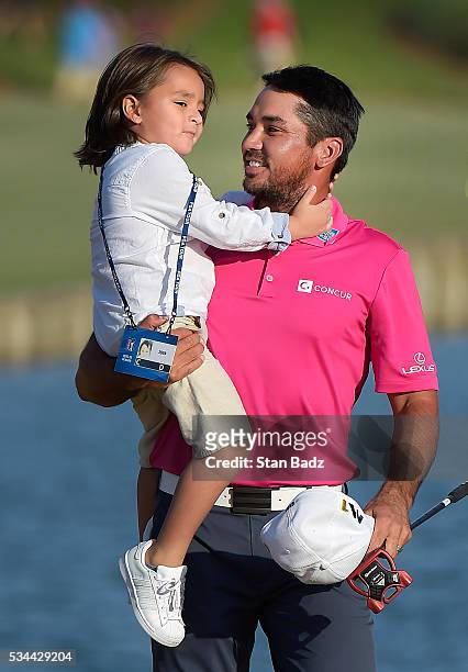 Jason Day of Australia exits the 18th green while holding his son Dash after winning during the final round of THE PLAYERS Championship on THE...
