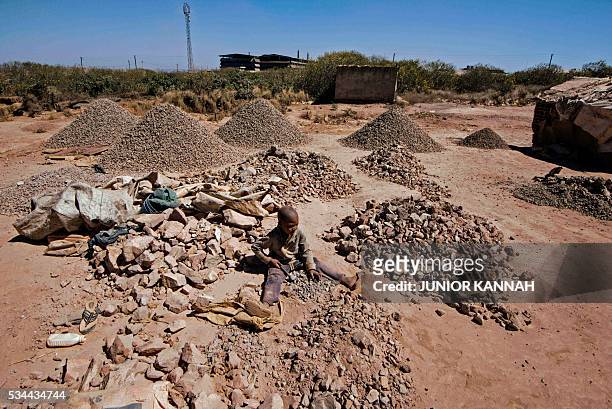 Child breaks rocks extracted from a cobalt mining at a copper mine quarry and cobalt pit in Lubumbashi on May 23, 2016. The price of copper has...