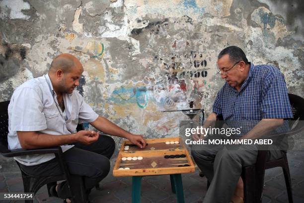 Palestinian men play backgammon in Gaza City on May 26, 2016.