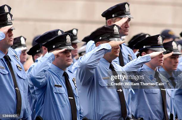 Philadelphia police officers salute as pallbearers carry the casket of Philadelphia Police Officer Gennaro Pellegrini Jr. To St. Anne's Church for a...
