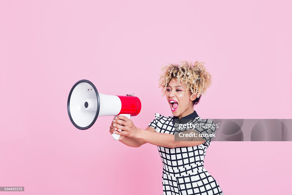 Afro American young woman shouting into megaphone