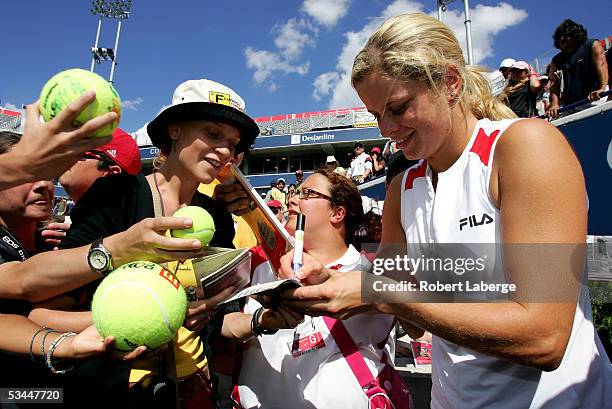 Kim Clijsters of Belgium signs the passeport of Belgian spectator Kristin Van De Vijver after defeating Justine Henin-Hardenne of Belgium 7-5, 6-1 in...