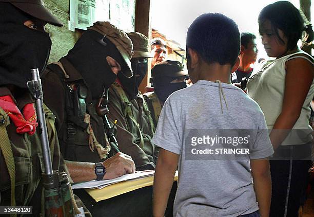 Subcomandante Marcos , leader of the Mexican Zapatista Army of National Liberation signs autographs for the children during the third meeting with...